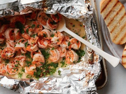 Fotografija škampov na žaru z žara v folijski vrečki